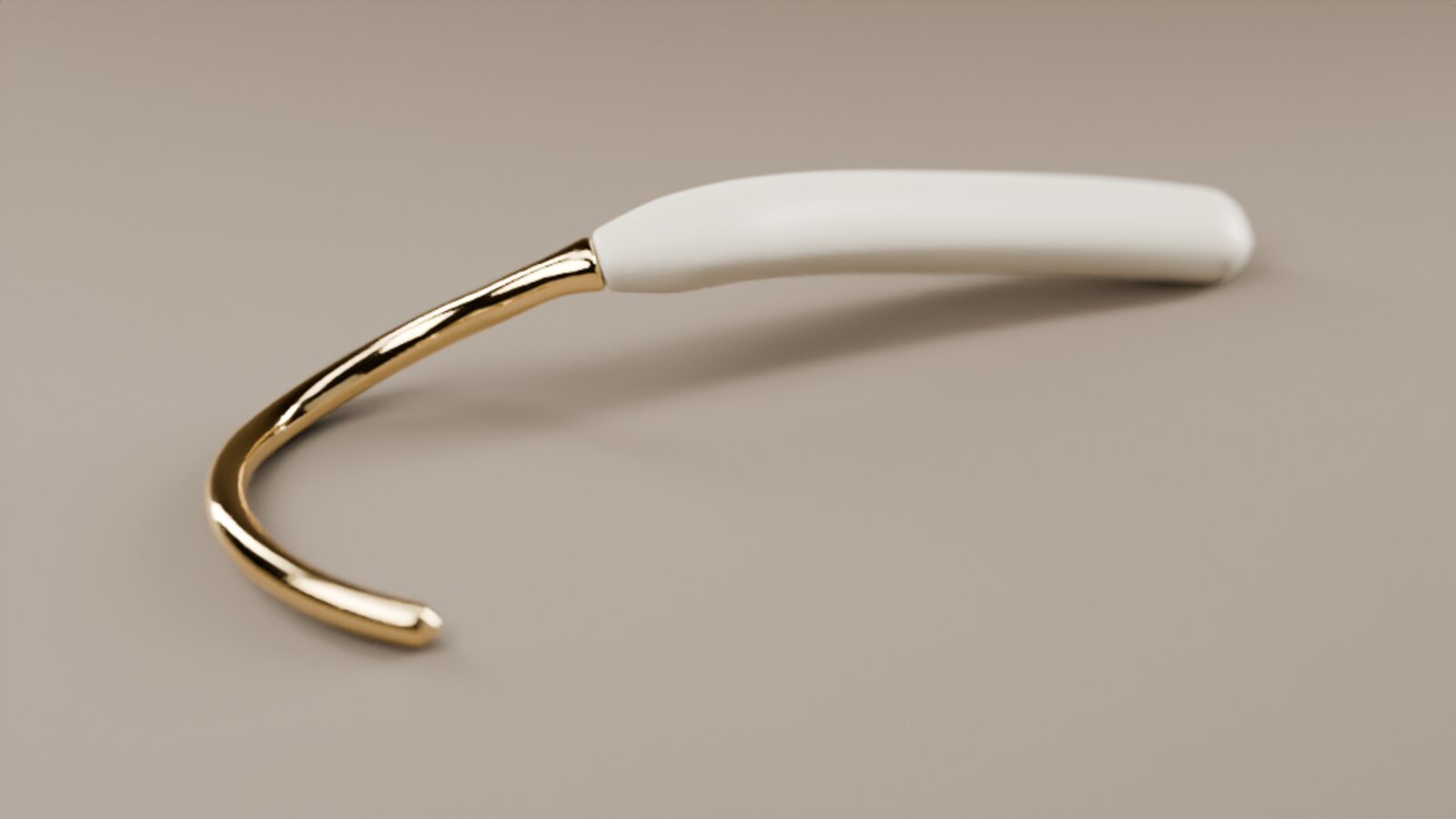 The nou cuff: a thin gold arc that hooks over the top of the ear, joined to a slim ivory pod that rests behind it.